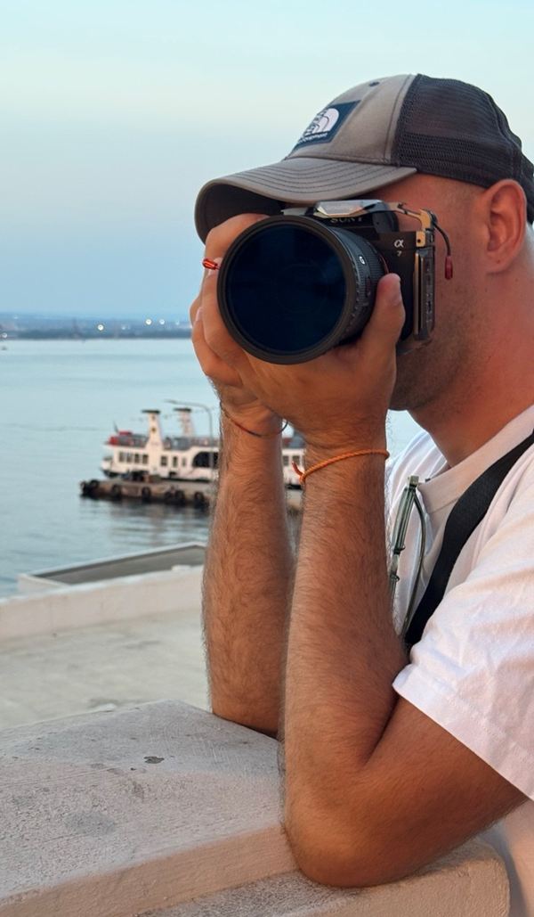 Yaro photographing with a telephoto lens by the sea