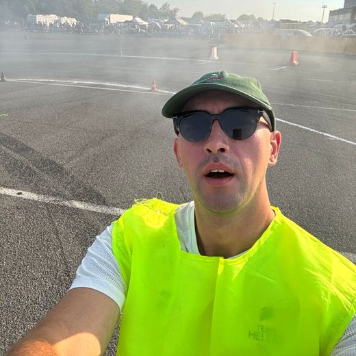 Yaro taking a selfie in a hi-vis vest at a drift event