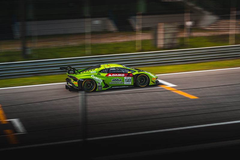 Green Lamborghini Huracán GT3 at speed on the track