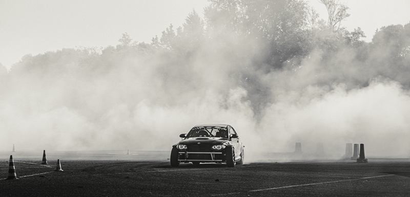 Black and white shot of a drift car in a cloud of smoke