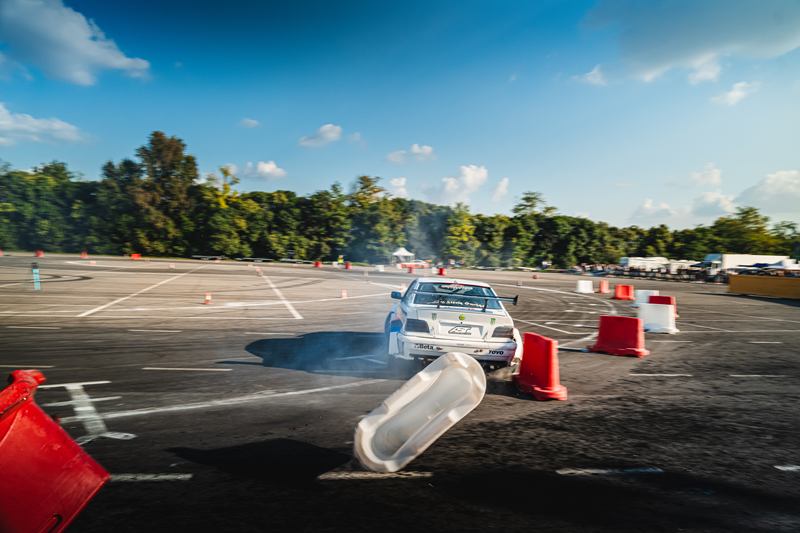 Drift car sliding between cones, one cone flying through the air