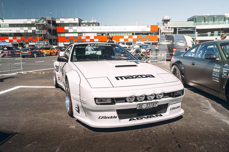 White widebody Mazda RX-7 in the paddock