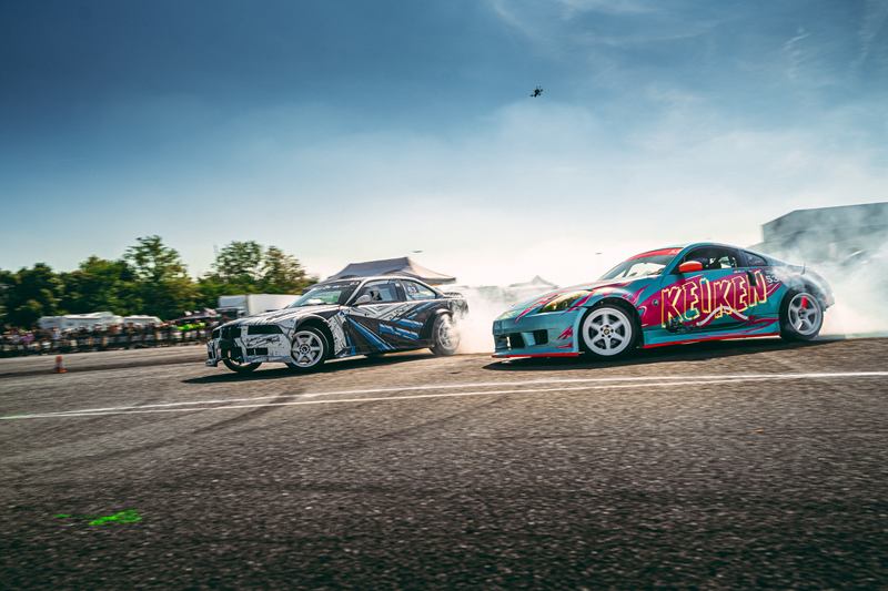 Two drift cars sliding in tandem with tyre smoke
